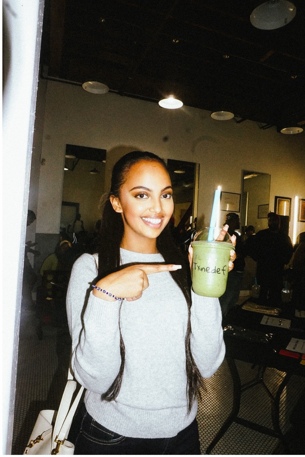 A guest holding a green Txnedef smoothie at the second anniversary