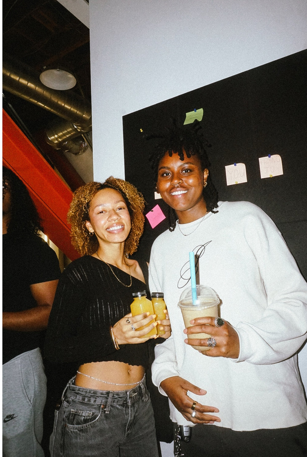 Two guests holding drinks at Txnedef’s second anniversary smoothie social
